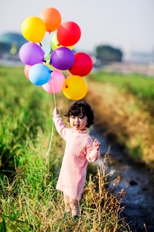 Spelen van het meisje met ballons op tarweveld