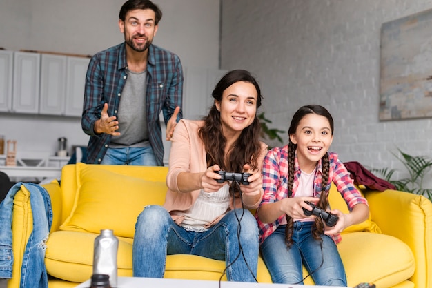 Spelen van videogames in woonkamer en gelukkige familie Premium Foto