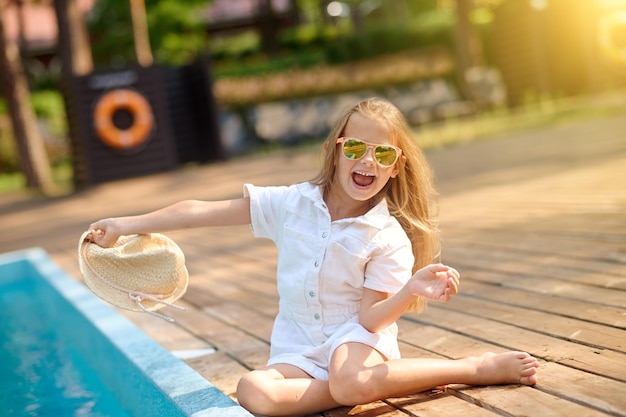 Spelend kind. Schattig blond meisje speelt in de buurt van het zwembad