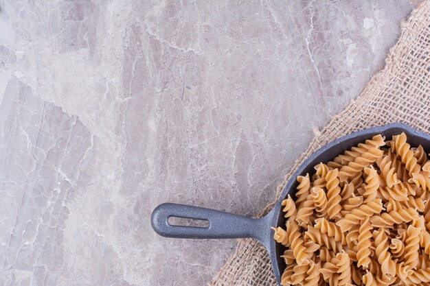 Spiraalvormige pasta's in een zwarte ijzeren pan
