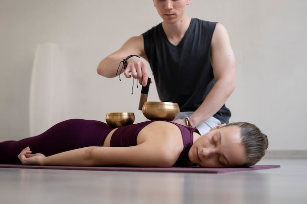 Spirituele jonge man en vrouw die binnen yoga beoefenen