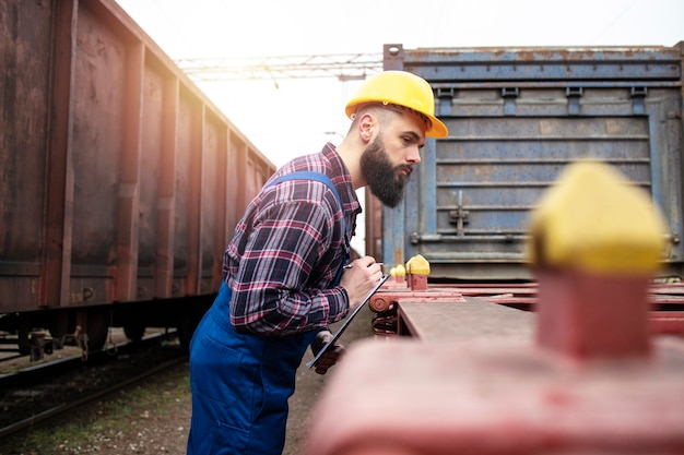 Spoorwegarbeider die ruimte controleert voor het verschepen van vrachtcontainer