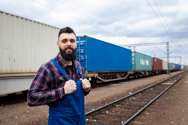 Gratis foto spoorwegarbeider die trots bij treinstation staat