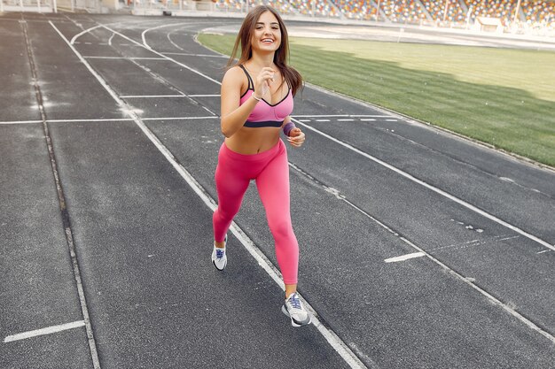 Sport meisje in een roze uniform loopt in het stadion