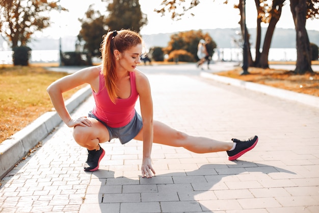 Sportenmeisje in een park van de ochtendzomer