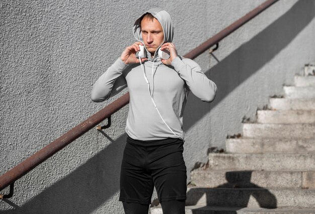 Sportieve jonge man zijn koptelefoon voorbereiden