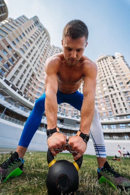 Sportieve man die traint met kettlebell.