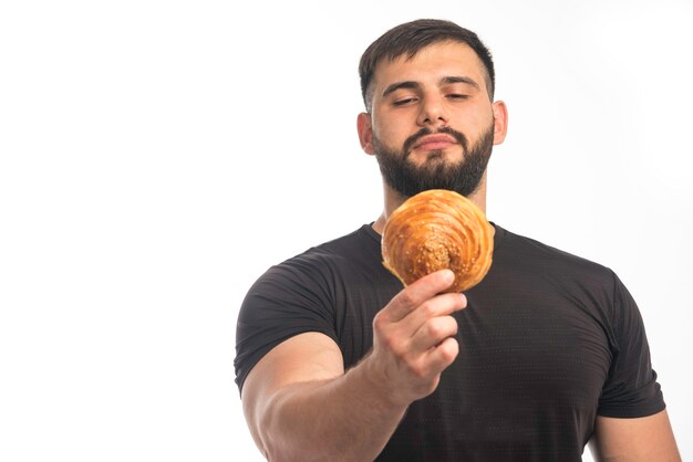 Sportieve man in zwart shirt met donut en zijn onverschilligheid.