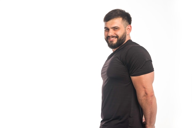 Sportieve man in zwart shirt met zijn triceps