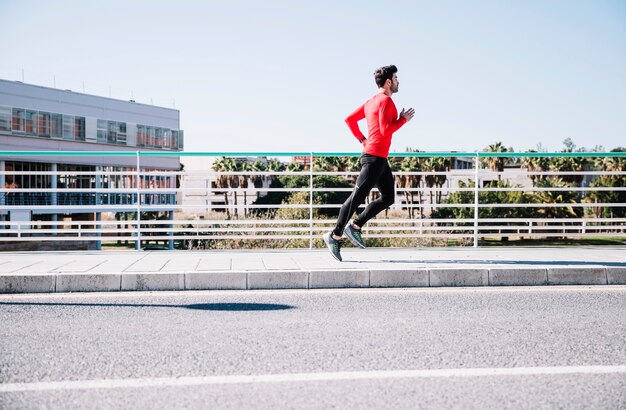 Sportieve man sprinten in de buurt van de weg