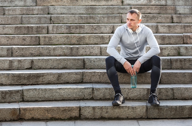 Sportieve op trappen rusten en mens die weg kijken