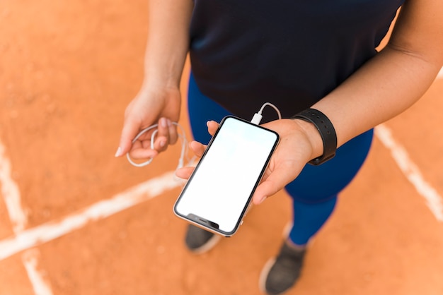 Sportieve vrouw die smartphonemalplaatje voorstelt