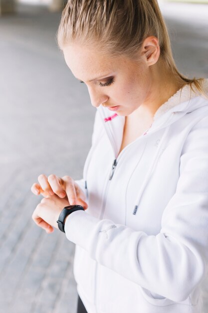 Sportieve vrouw die smartwatch bekijkt