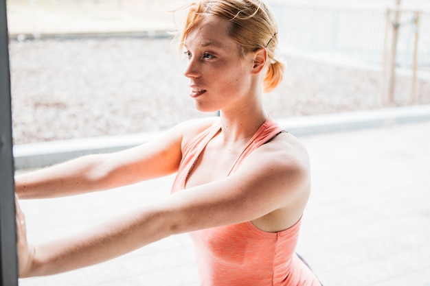 Sportieve vrouw die zich uitstrekt in de stedelijke omgeving