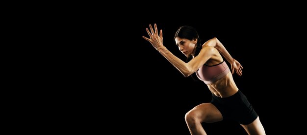 Sportieve vrouw professionele lopende atleet in uniform poseren geïsoleerd over witte studio achtergrond