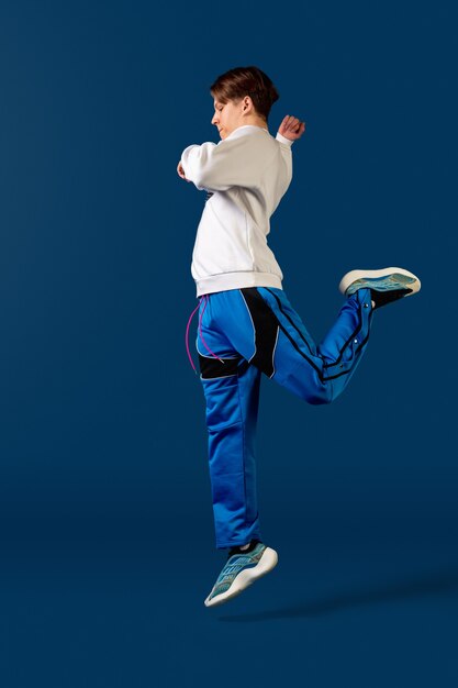 Springen. Old-school ouderwetse jonge man dansen geïsoleerd op blauwe studio