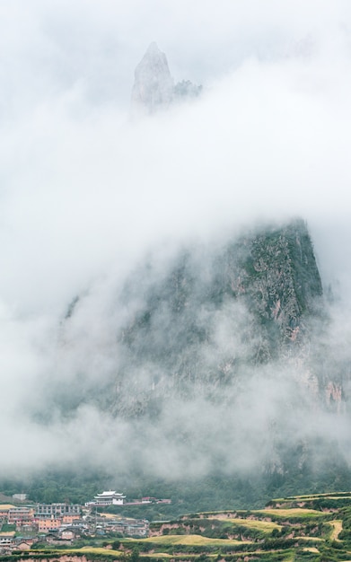 Stad en een rotsachtige berg bedekt met mist