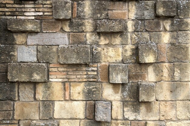 Stained bakstenen muur met ongelijke blokken