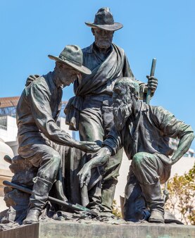 Standbeeld van drie goudzoekers die goudklompjes bekijken in san francisco, vs op 5 augustus 2011