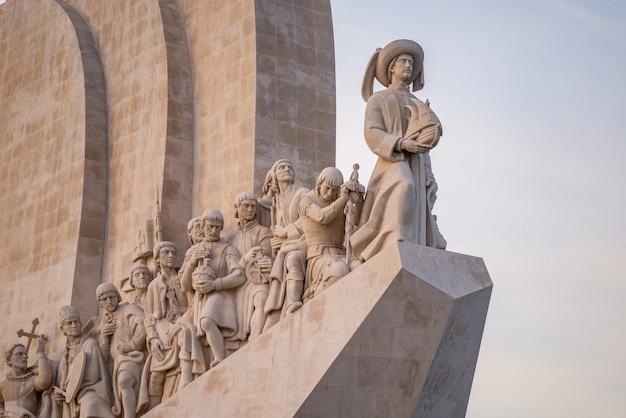 Standbeelden op het monument van ontdekkingen onder het zonlicht in lissabon in portugal