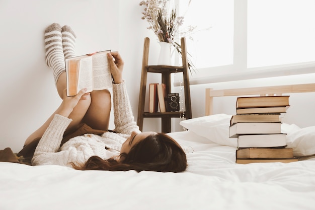 Stapel boeken in de buurt van het lezen van vrouw