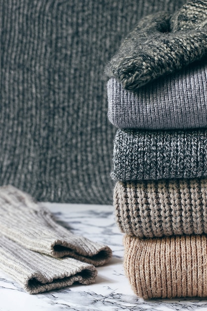Stapel gezellige gebreide truien. Herfst-winterconcept, gebreide wollen truien. Stapel gebreide winterkleding, truien, gebreide kleding