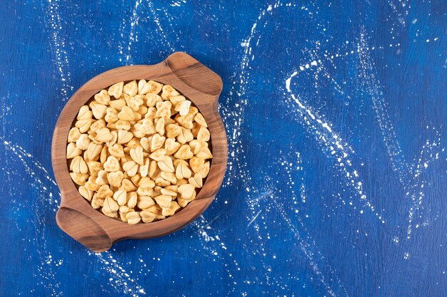 Stapel gezouten hartvormige crackers geplaatst op een houten bord.