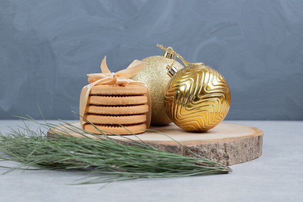 Stapel koekjes gebonden met lint en kerstballen op een houten bord. Hoge kwaliteit foto