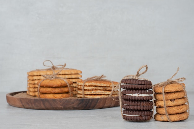 Stapel koekjes gebonden met touw op houten plaat.