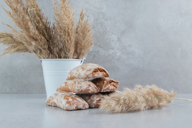 Stapel koekjesverpakkingen en bundel van de stengels van het verengras op marmeren achtergrond.