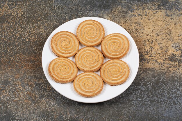 Stapel lekkere koekjes op een witte plaat.