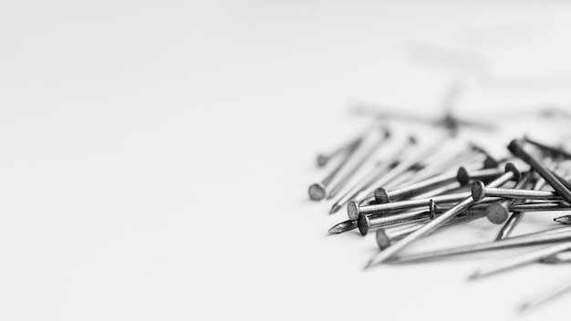 Stapel metalen nagels op witte tafel