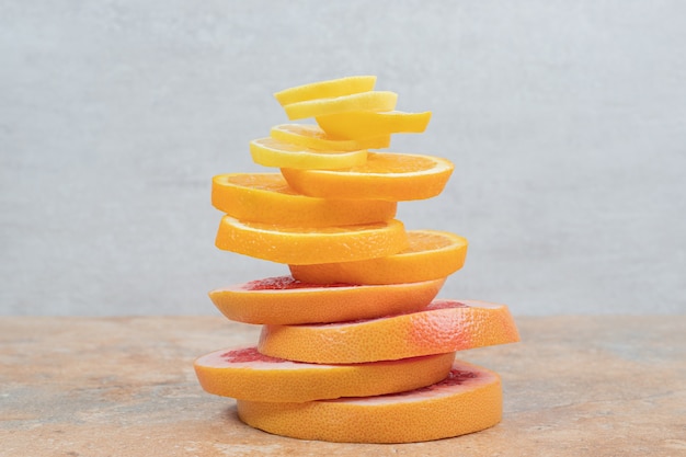 Stapel plakjes citroen, sinaasappel en grapefruit op marmeren tafel. Hoge kwaliteit foto