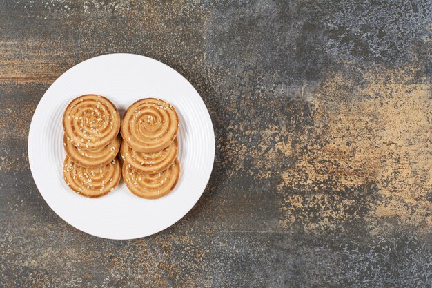 Stapel smakelijke ronde koekjes op witte plaat.