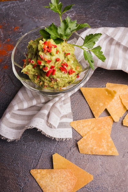 Gratis foto stapel van nachos dichtbij guacamole in kom en servet