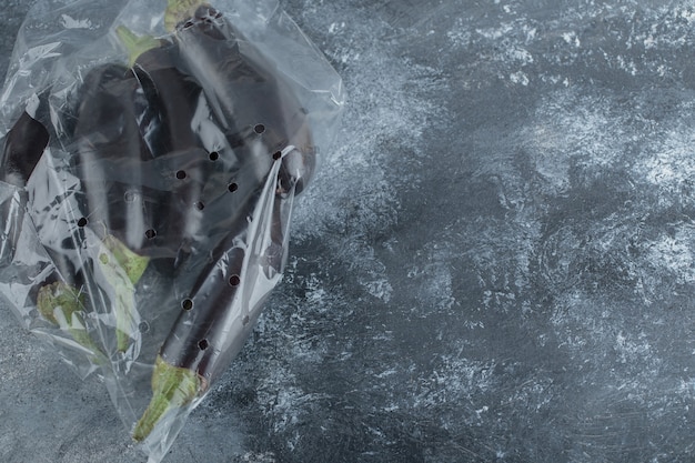 Stapel verse aubergines in plastic zak.