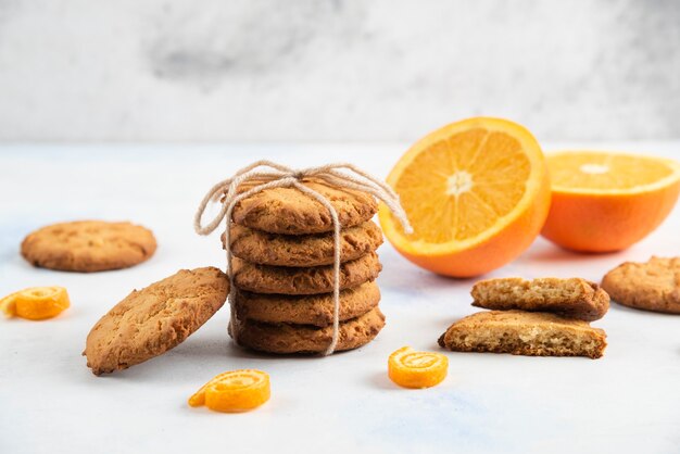 Stapel zelfgemaakte verse koekjes met biologische sinaasappelen.