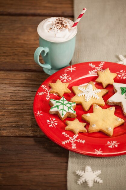 Star-vormige cookies op een rode plaat en koffie met slagroom