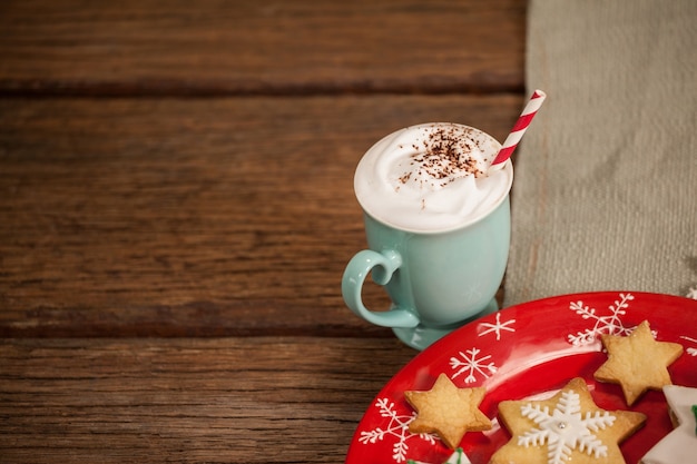 Star-vormige cookies op een rode plaat en koffie met slagroom