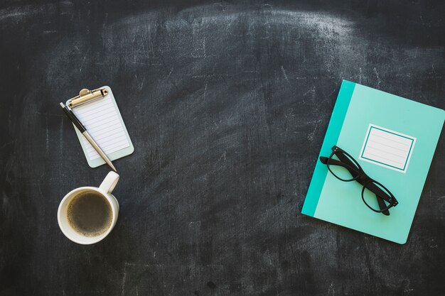 Stationeries en koffiekopje op blackboard