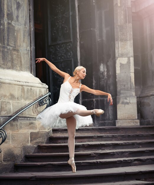 Stel je voor dat ze optreedt. Volledige opname van een getalenteerde ballerina die danst in de buurt van een oud kasteel