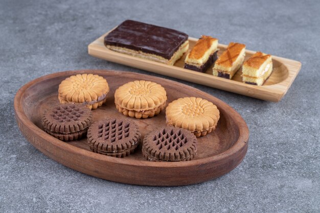 Stelletje heerlijke koekjes en plakjes cake op houten borden