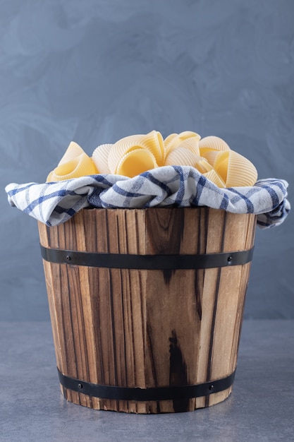 Gratis foto stelletje rauwe shell pasta in houten emmer.