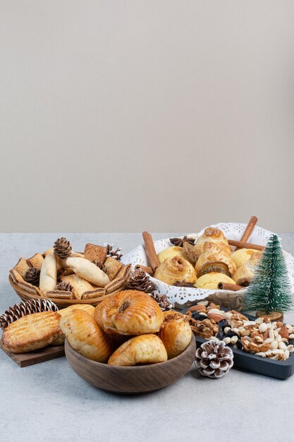 Stelletje verschillende koekjes, noten en dennenappels in kommen. Hoge kwaliteit foto