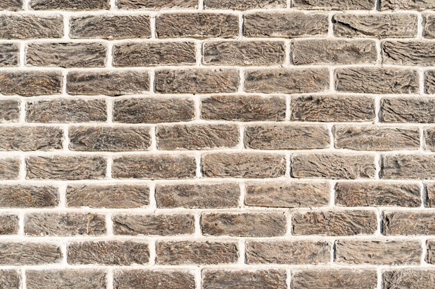Stenen muur. Textuur van grijze roombaksteen met witte vulling