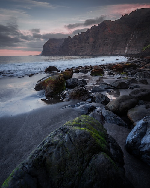 stenen op het strand onder de bewolkte hemel bij zonsondergang