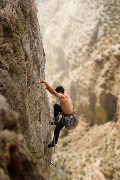 Gratis foto sterke man die op een berg klimt