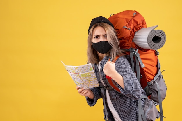 sterke reizigersvrouw met zwart masker met kaart