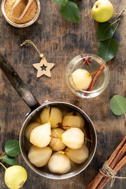 Stewed pears pot zoete peren gestoofd in siroop of witte wijn op een groene houten tafel het kookproces