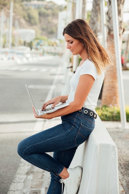 Stijlvol meisje met een laptop buiten